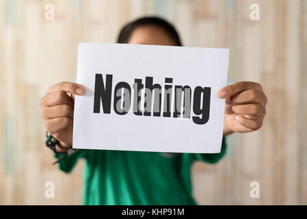 Asian boy holding paper note écrite 'rien' word word.rien sur papier Banque D'Images