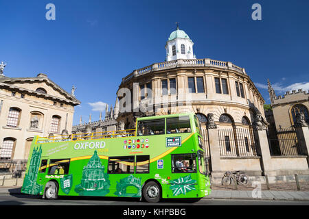 UK, Oxford, un autobus qui passe la visite guidée d'Sheldonian Theatre. Banque D'Images