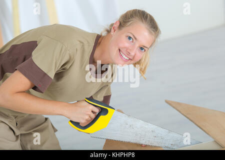 Femme à l'aide de scie à main Banque D'Images