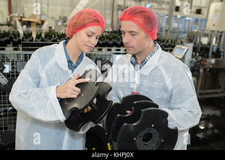 Les ouvriers d'usine contrôle de marchandises sur la ligne de production Banque D'Images