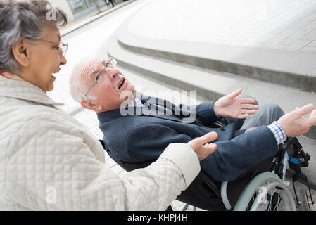 Man qui est poussé par femme en fauteuil roulant Banque D'Images