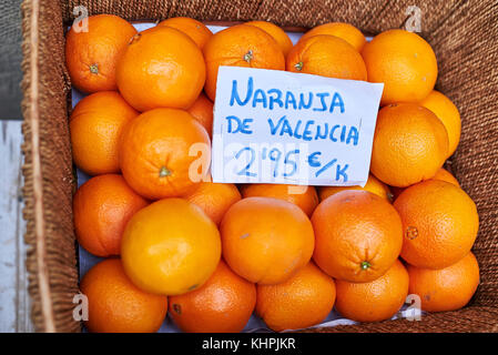 Les oranges de Valence, en Espagne, dans un panier en osier d'un marché. (Cartel en espagnol montrant le prix) Banque D'Images