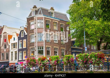 Des vélos hollandais traditionnels garé sur canal à Amsterdam Banque D'Images