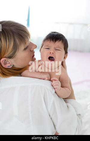 Mère essaie de réconforter bébé qui pleure Banque D'Images