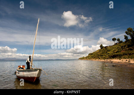 Un pêcheur navigue sur le lac Titicaca, près de la ville de llachón. capachica peninsula à vers la terre ferme. llachon, près de Puno, Pérou. Banque D'Images