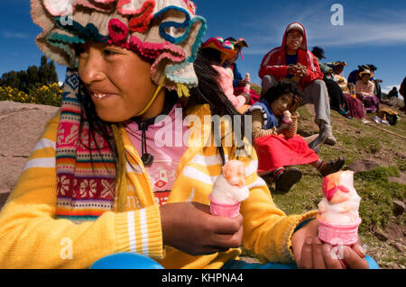 Plusieurs femmes du village de Llachón, vêtues de costumes régionaux, assistent à un match de football en dégustant une glace. Péninsule de Capachica, à proximité Banque D'Images