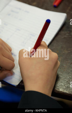 Élève de l'école à écrire des notes dans un livre d'exercices, les étudiants, les mains, l'enregistrement des résultats de la science de l'ordinateur portable Banque D'Images