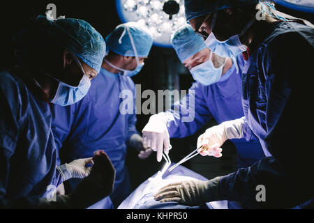 Surgeons performing surgery professionnel en salle d'opération de l'hôpital. L'équipe médicale d'effectuer une procédure chirurgicale en salle d'opération. Banque D'Images