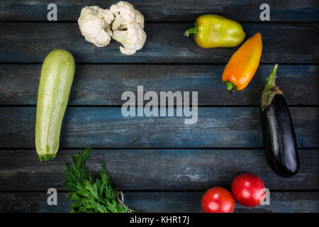 Ingrédients pour salade de légumes grillés avec courgettes, aubergines, oignons, poivrons et tomates. sur un fond en bois. Vue de dessus Banque D'Images