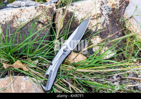 Couteau de poche avec une carabine. Couteau photo dans la nature. Banque D'Images