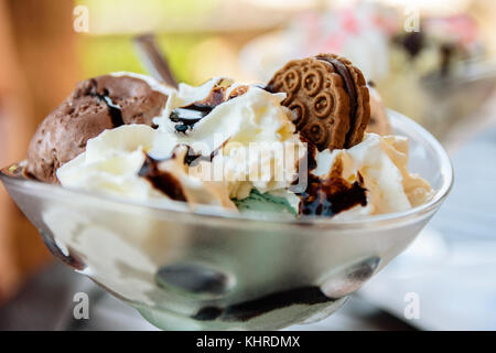 La menthe et la crème glacée au chocolat avec sauce et cookie dans bol en verre Banque D'Images