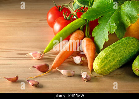 Les concombres, les tomates, les carottes, l'ail, les courgettes sur table en bois. fond de légumes. copier l'espace. Banque D'Images