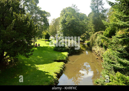 Les touristes se détendre au bord de la rivière dans pavilion gardens buxton Banque D'Images