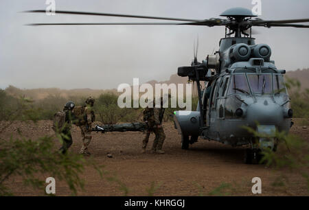 Une armée de l'air pararescuemen affecté à la 48e Escadron de l'Air française et déplacer un patient simulé commandos d'un Eurocopter EC-725 pour tomburns Banque D'Images