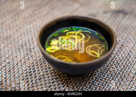 La soupe miso dans un bol en céramique marron servi sur une table Banque D'Images