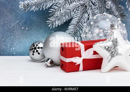 L'argent l'étoile de Noël avec boîte cadeau rouge et de décorations de noël contre fond bleu Banque D'Images