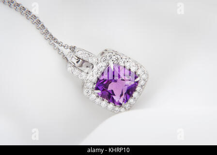 Pendentif en or blanc avec améthyste violet rose et diamants sur le doux fond flou Banque D'Images