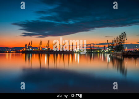 Colorful sunset over sea port et grues industrielles, Varna, Bulgarie Banque D'Images
