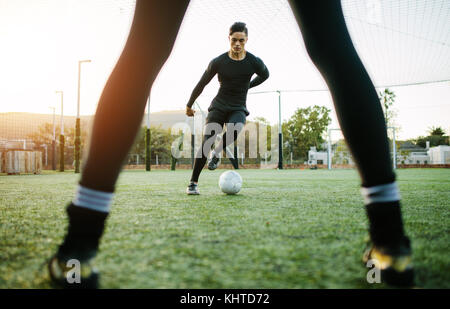 Joueurs de football au cours de la pratique sur terrain de football. Jeune footballeur jouant sur la pelouse. Banque D'Images