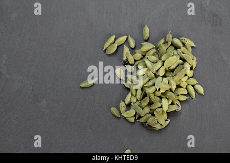 Cardamone pods sur table en pierre grise Banque D'Images