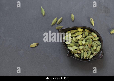 Le cardamome dans un bol sur la table en pierre grise Banque D'Images