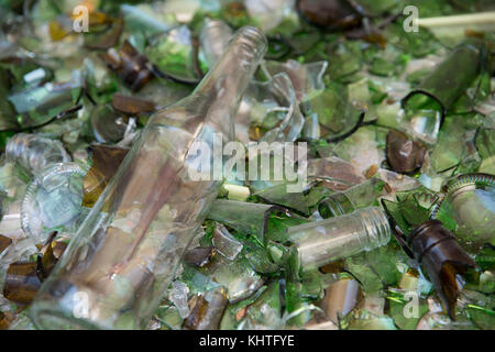 Bouteille de vin sur un lit de verre ayant échappé à l'aplatisseur à une installation de recyclage. Contexte Banque D'Images