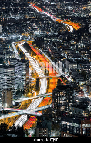 Vue aérienne de j-5 Interstate highway crossing Seattle Downtown. l'heure de pointe des sentiers sinueux de la lumière laisse entre bâtiments sombres Banque D'Images