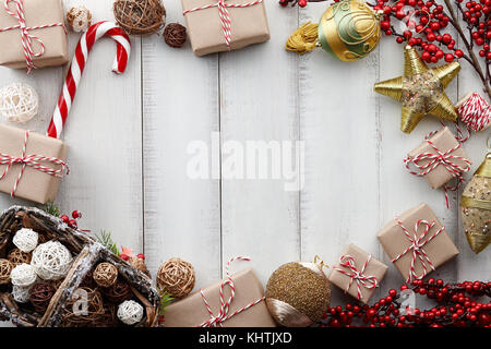 Les jouets de Noël, décorations, cadeaux et coffrets cadeaux enveloppés dans du papier kraft blanc sur fond de bois, copy space Banque D'Images