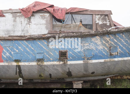 Vue latérale d'un vieux bateau avec des écaillages de peinture au port de Kingholm Quay sur la rivière Nith, Dumfries et Galloway, en Écosse. Banque D'Images