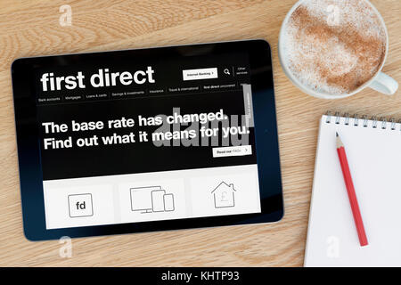 Le premier site web direct sur un iPad tablet device qui repose sur une table en bois à côté d'un bloc-notes et un crayon et une tasse de café (rédaction uniquement) Banque D'Images