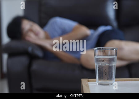 Femme âgée dormir à la maison de l'eau sur la table de verre retraite médicale santé sommeil Banque D'Images