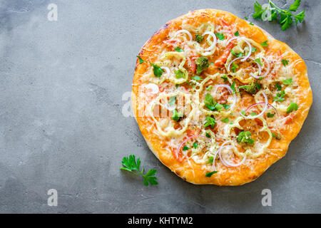 Pizza végétarienne sur fond de béton rustique. italien Pizza aux légumes et fromage de près. Banque D'Images