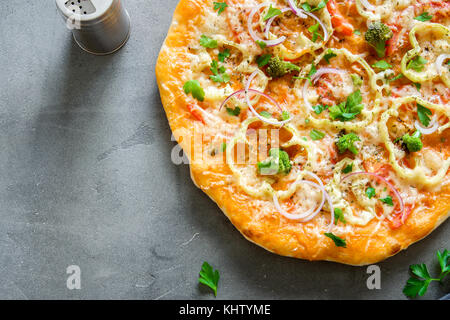 Pizza végétarienne sur fond de béton rustique. italien Pizza aux légumes et fromage de près. Banque D'Images