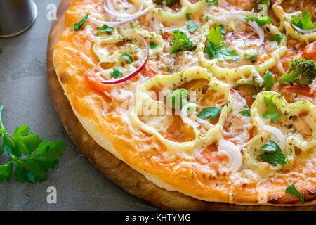 Pizza végétarienne sur fond de béton rustique. italien Pizza aux légumes et fromage de près. Banque D'Images