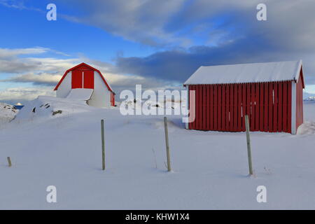 Rouge-blanc-cabanes de pêcheurs traditionnels robuer maintenant pour les touristes à côté de fv 862 Road sur la rive n.de l'île de gimsoya sous d'épaisses couvertures de neige près de hovsvi Banque D'Images