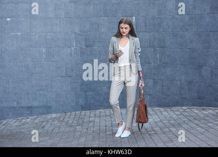 Businesswoman outdoors, using smartphone Banque D'Images