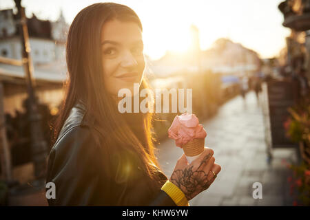 Portrait of young woman holding ice cream, tatouages sur part Banque D'Images