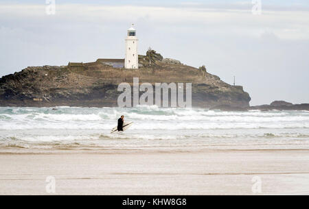 Godrevy Bay Cornwall novembre 2017 - Un surfeur dans la mer avec le phare de Godrevy derrière Banque D'Images