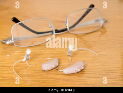 Gros plan d'une paire de petits appareils auditifs modernes sur la table de chevet Banque D'Images