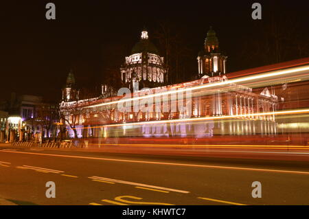 Les sentiers de la lumière d'un autobus qui passe Belfast City Hall Banque D'Images