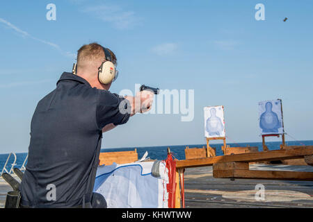 171114-N-VR594-0125 est de la mer de Chine (nov. 14, 2017) Mate du canonnier matelot Erik McCoy, à partir de la ville de granit, Ill., incendies un pistolet M9 lors d'un cours de qualification de petit calibre dans le poste de pilotage à bord de la classe Ticonderoga croiseur lance-missiles USS Princeton (CG 59). Princeton est partie de la Groupe aéronaval Nimitz en fonction d'un programme de déploiement de la 7ème Flotte américaine zone d'opérations à l'appui d'opérations de sécurité maritime et les efforts de coopération en matière de sécurité dans le théâtre. La Flotte américaine du Pacifique a patrouillé dans la région Indo-pacifique couramment pour plus de 70 ans la promotion de la sécurité régionale, stabil Banque D'Images