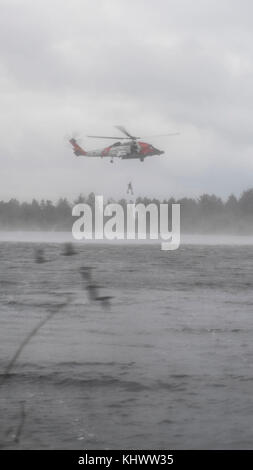 Les gardes-côtes de la U.S.C.G. Fleuve Columbia secteur effectuer une démonstration de sauvetage en eau avec un hélicoptère Jayhawk MH-60 pour les participants de l'U.S 2017 -La Chine change la gestion des catastrophes au Camp Rilea, Ore., 16 novembre. L'assemblée annuelle du Pacifique de l'armée des États-Unis (USARPAC) événement de la coopération en matière de sécurité avec l'Armée populaire de libération (APL) est une occasion de partager les enseignements tirés afin d'accroître la capacité de réagir aux catastrophes naturelles dans la région du Pacifique. (U.S. Air Force photo de Nathan H. Barbour) Banque D'Images