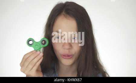 Belle cheerful girl Playing with green fidget spinner sur fond blanc Banque D'Images