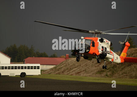 L'équipage d'un hélicoptère Jayhawk MH-60, de la Garde côtière de la rivière Columbia secteur, des terres dans un terrain de stationnement à la U.S. National Guard Training Base Camp Rilea situé dans la région de Warrenton, Ore., pour les États-unis/Chine change la gestion des catastrophes, le 16 novembre 2017. Des soldats de l'armée des États-Unis, du Pacifique de la Garde nationale de l'Oregon et de la République populaire de Chine, Sud de l'Armée populaire de libération du commandement de théâtre ont pris part à la 13ème itération de l'échange, qui a pour but de partager les leçons retenues au sujet de l'aide humanitaire et secours en cas de catastrophe. U.S. Coast Guard photo de Maître de 1re classe L Banque D'Images