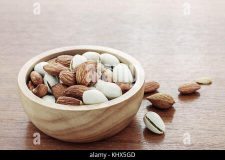 Les amandes dans un bol sur les planchers de bois. Banque D'Images