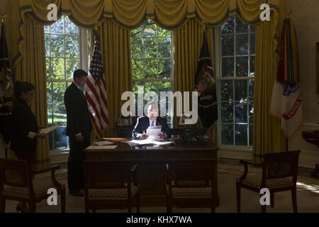 WASHINGTON, DC -17 OCTOBRE : le président Donald Trump est vu dans la lumière tôt le matin alors qu'il examine et signe des documents dans le bureau ovale de la Maison Blanche, mardi 17 octobre 2017, à Washington, D.C. People : Donald Trump, rejoint par le vice-président Mike Pence Banque D'Images
