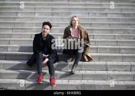 Un couple d'amis sont assis sur les marches
