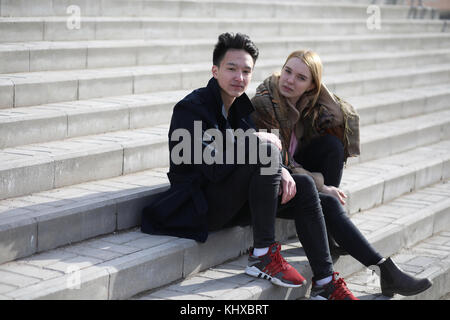 Un couple d'amis sont assis sur les marches