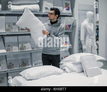 Customer homme choisit le linge de lit dans le supermarché mall magasin. Banque D'Images