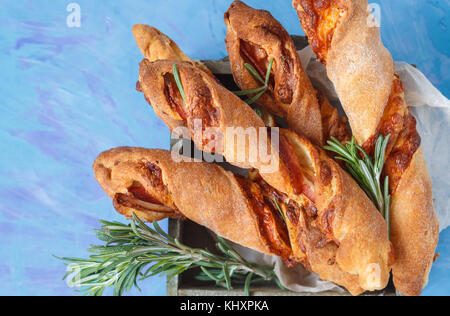 Bâtonnets de fromage savoureux avec du bacon, les herbes en boîte en bois. vue d'en haut, sur fond bleu. viande  + fromage snack pour la bière, le concept de parti, jour de Thanksgiving. Banque D'Images